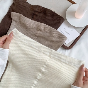 Detail of ribbed knit texture on stretch thermal leggings in off-white and brown tones