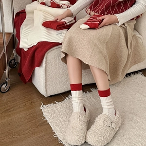 Detail of red and white striped knit crew socks with thick texture for winter warmth