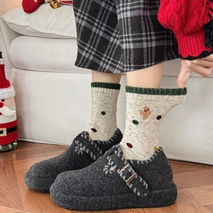 Détail de chaussettes de Noël en laine avec des chaussons en peluche gris foncé douillets