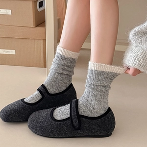 Detail of warm grey winter Mary Jane flats paired with thick cable knit socks
