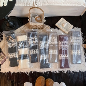 Detailed view of assorted knit leg warmers in individual packaging with floral patterns