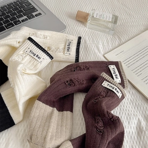 Detail of vintage distressed knit wool socks with torn design and brand label