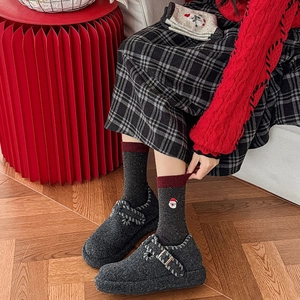 Gros plan détaillé de chaussettes festives en laine avec broderie Père Noël et souliers