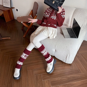 Retro red knit leg warmers with snowflake pattern shown in a cozy home setting