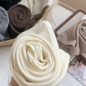 Detailed close-up of thick ribbed knit texture on warm wool leggings in neutral tones
