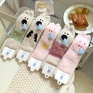 Detail showing five pairs of thick coral fleece socks with 3D cartoon pig ornaments