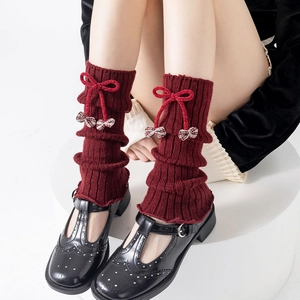 Deep red knit leg warmers with bows and plaid charms styled with Mary Jane shoes