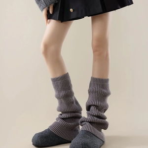 Close-up of gray vertical ribbed knit leg warmers showing thick texture and soft folds
