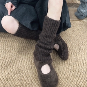 Detail of dark brown chunky knit leg warmers paired with plush Mary Jane shoes