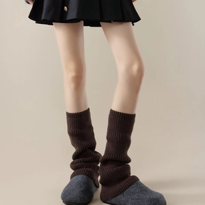 Close-up of dark brown vertical ribbed knit leg warmers showing thick texture and soft wool