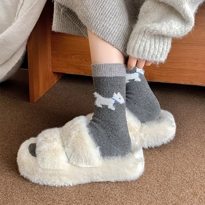 Detail von Wollsocken mit süßer weißer Hundestickerei und dicker Stricktextur