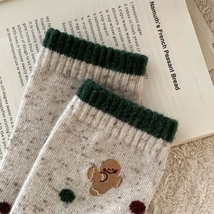 Détail macro de chaussettes de Noël en laine avec broderie petit biscuit et pois