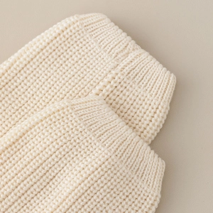 Macro shot of beige vertical ribbed knit fabric texture on college style leg warmer