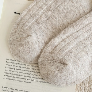 Close-up of oatmeal knit socks with thick texture and warm cable pattern details