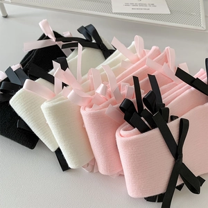 Detailed knit texture and silk bow design on ballet-style leg warmers in multiple colors