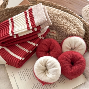 Macro view of warm red and white striped knit socks with thick plush fleece lining detail