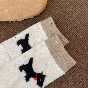 Detailansicht der gesprenkelten Wollsocken mit schwarzem Terrier-Motiv und braunem Bund