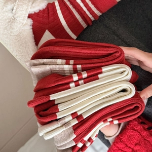 Detailed view of thick red and white striped knit socks with ribbed texture and warm fabric