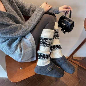 Detail of vintage knit leg warmers with snowflake patterns and retro jacquard texture