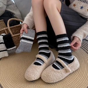 Dettaglio di calze di lana a righe grigie abbinate a scarpe Mary Jane pelose