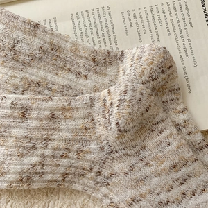Close-up of thick knitted bear socks featuring brown marl texture and ribbed texture