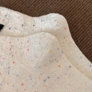 Nahaufnahme von Wollsocken mit Konfetti-Strickmuster und weicher, gerippter Fersenstruktur