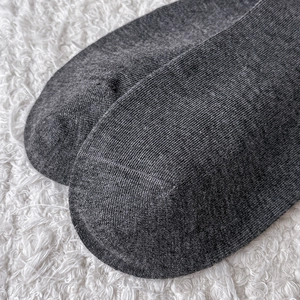 Macro detail of dark grey knit sock showing flat toe seam and fine ribbed texture
