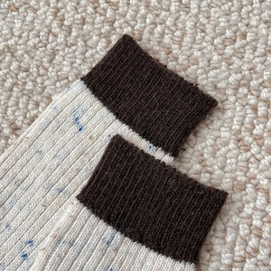 Close-up of vintage thick wool socks with ribbed cuffs and multicolored tweed knit texture