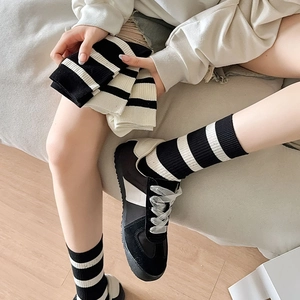 Close-up of black and white striped cotton socks with ribbed cuffs in a cozy home setting