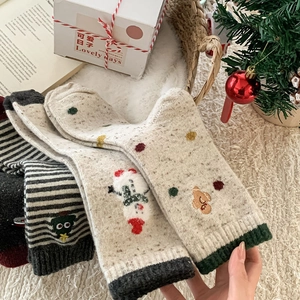 Détail de chaussettes de Noël en laine avec broderie bonhomme de neige sur fond peluche