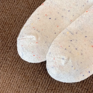 Nahaufnahme von Wollsocken im Fair-Isle-Stil mit farbig gesprenkeltem Strick und Textur
