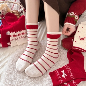 Detail of red and white wool socks with festive snowflake patterns and striped knits