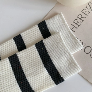 Detailed view of cream knitted socks with black stripes and colorful rainbow flecks