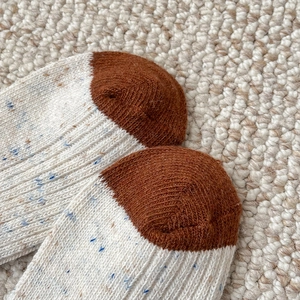 Close-up of contrast toe detail on thick wool socks with multi-color knit texture