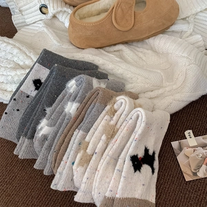 Detailansicht von Wollsocken im Fair-Isle-Stil mit Hundemotiv und grober Strickstruktur