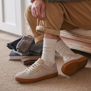 Detailed texture of thick beige knitted wool crew socks with retro rubber sole casual shoes