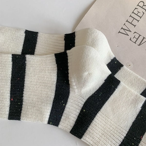 Detailed macro view of black and white striped knit socks with colorful nep yarn texture