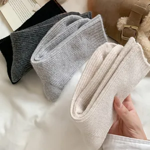 Detailed texture of rib-knit wool socks in four neutral colors for winter warmth