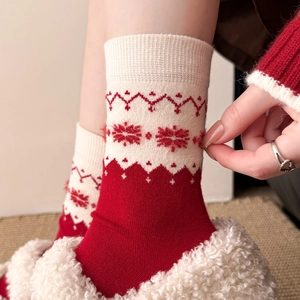 Detailed knit texture of red and beige winter socks with snowflake jacquard patterns