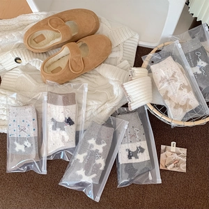 Detail von warmen Fair Isle Wollsocken und Fleecepantoffeln in einer Winterverpackung