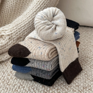 Detail showing colorful marl wool socks with ribbed texture and thick winter fabric