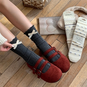 Detail of dark grey knit crew socks with white lace bow and vintage floral pattern