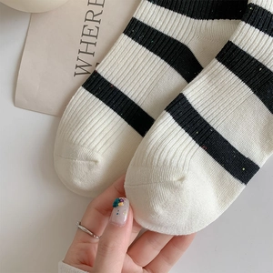 Macro detail of black and white striped cotton socks with colorful speckled knit texture