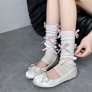 Balletcore style white knit leg warmers with pink bows and satin Mary Jane flats