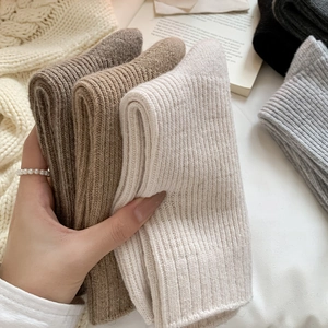 Close-up of thick ribbed wool socks in earthy tones showing soft knitted texture