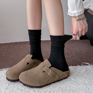 Classic brown suede mule clogs with adjustable metal buckle and cork footbed on model