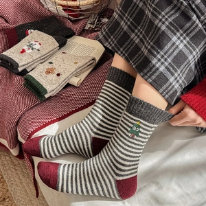 Détails de chaussettes en laine avec motifs de sapins de Noël et bonhommes de pain d'épice