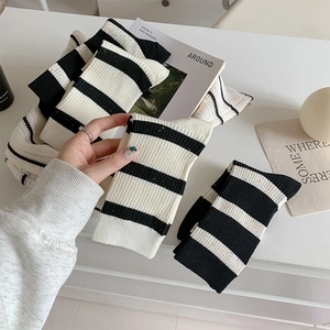 Close-up of black and white striped knit texture and ribbed elasticity of the mid-calf socks