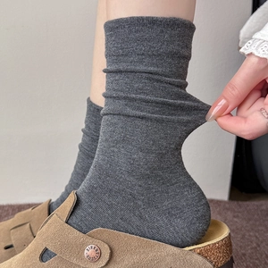 Detail of dark grey ribbed cotton socks showing high elasticity and slouchy style texture