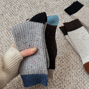 Close-up of thick wool blend socks with colorful speckles and contrast knit texture